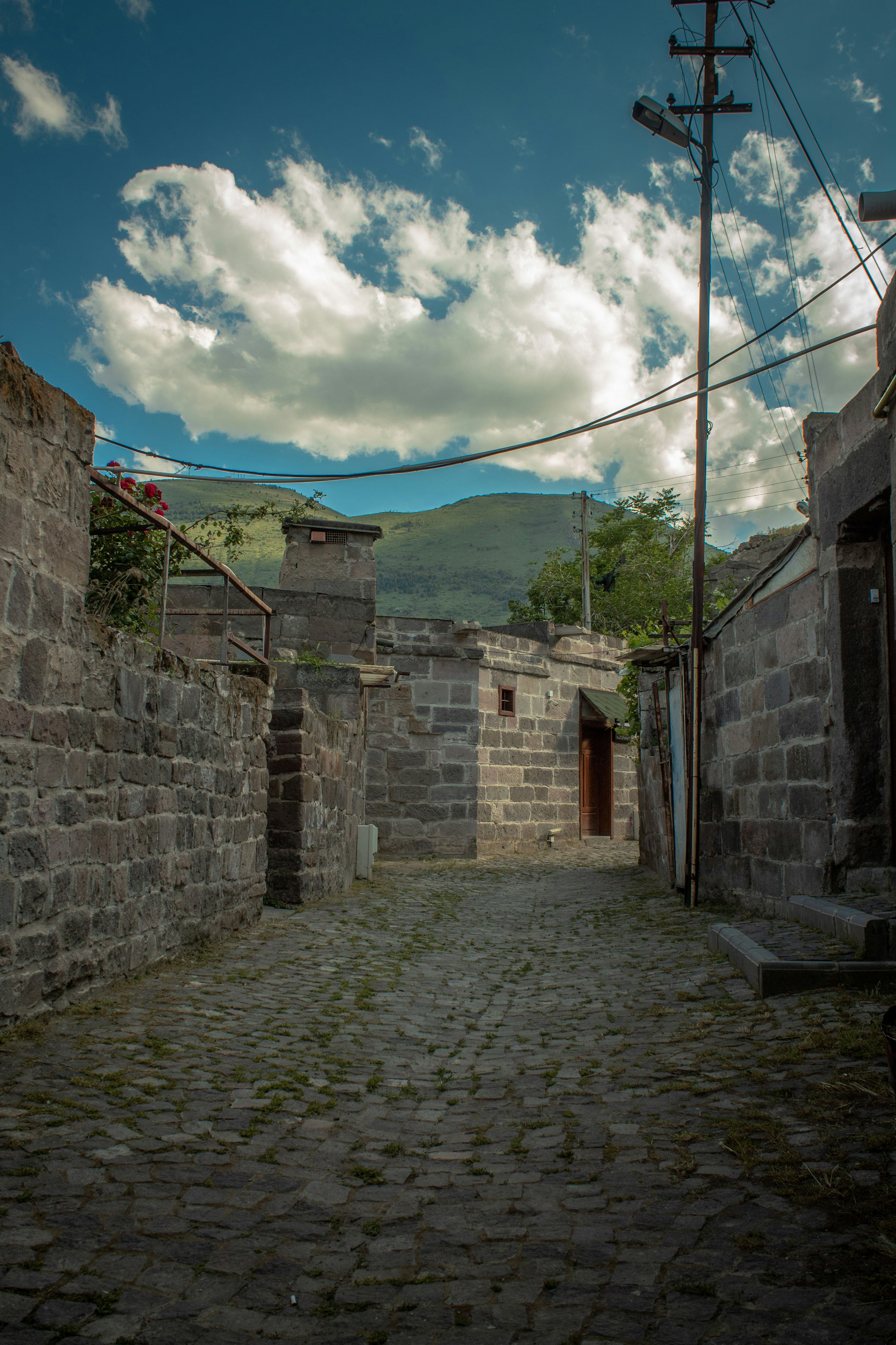 gray brick wall under blue sky and white clouds during daytime