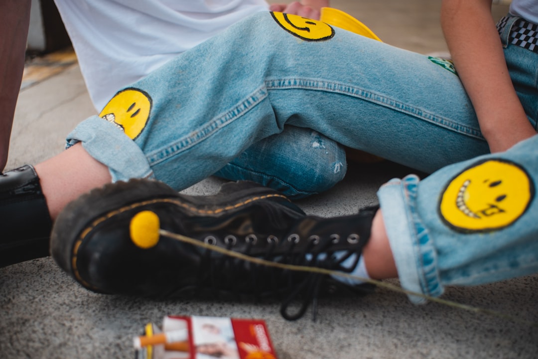 person in blue denim jeans and black converse all star high top sneakers