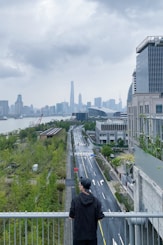 man in black jacket sitting on gray concrete bench during daytime