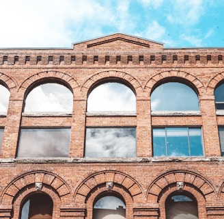 brown concrete building under white clouds during daytime