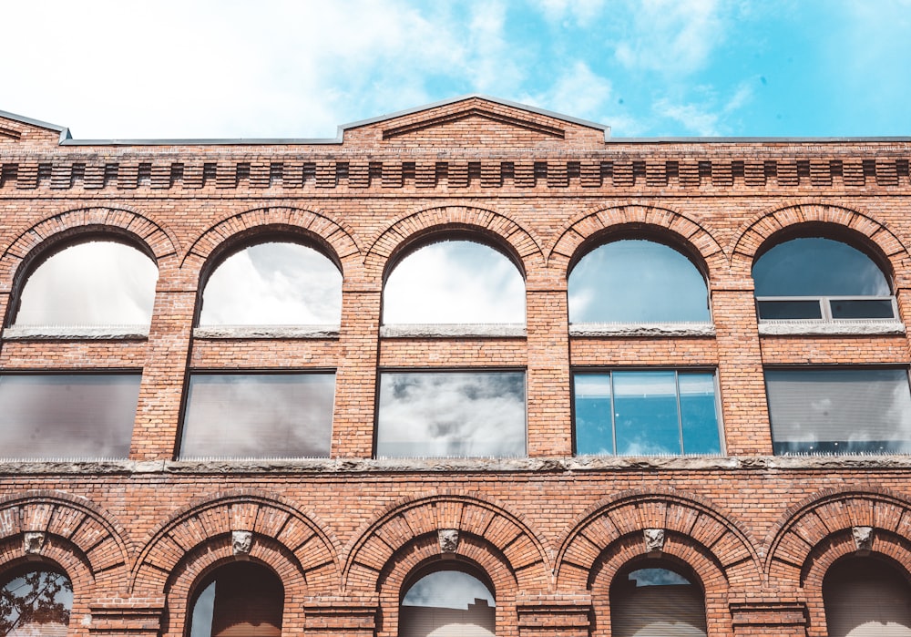 brown concrete building under white clouds during daytime