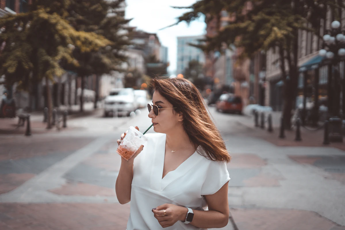 Perempuan menikmati minuman dingin di jalan kota