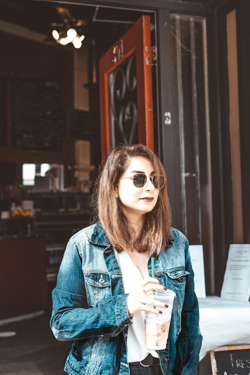 woman in blue denim jacket wearing sunglasses