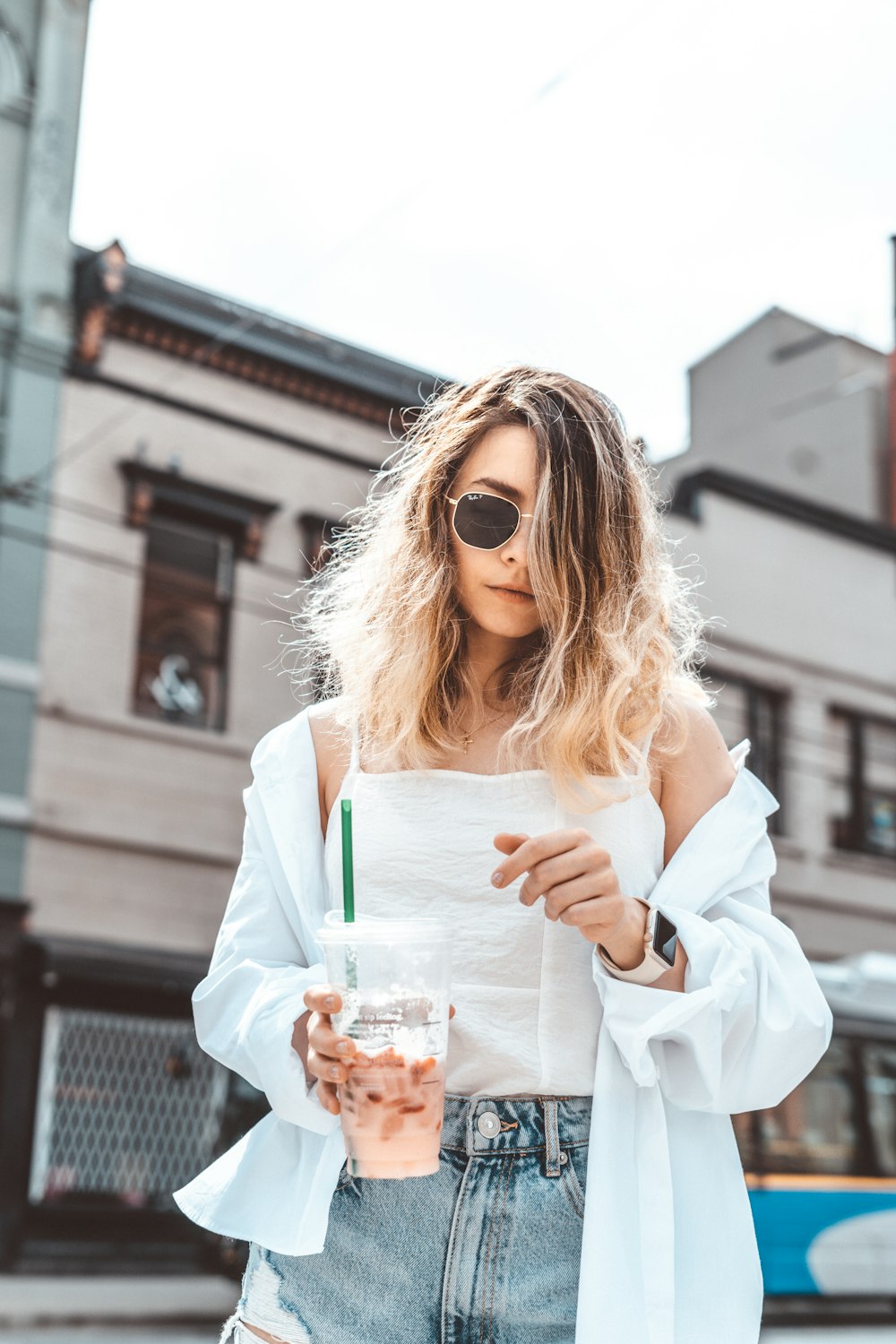 woman in white long sleeve shirt holding clear drinking glass