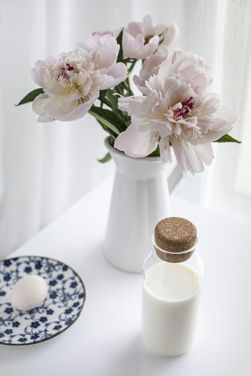 2 white and blue floral ceramic vase on white table