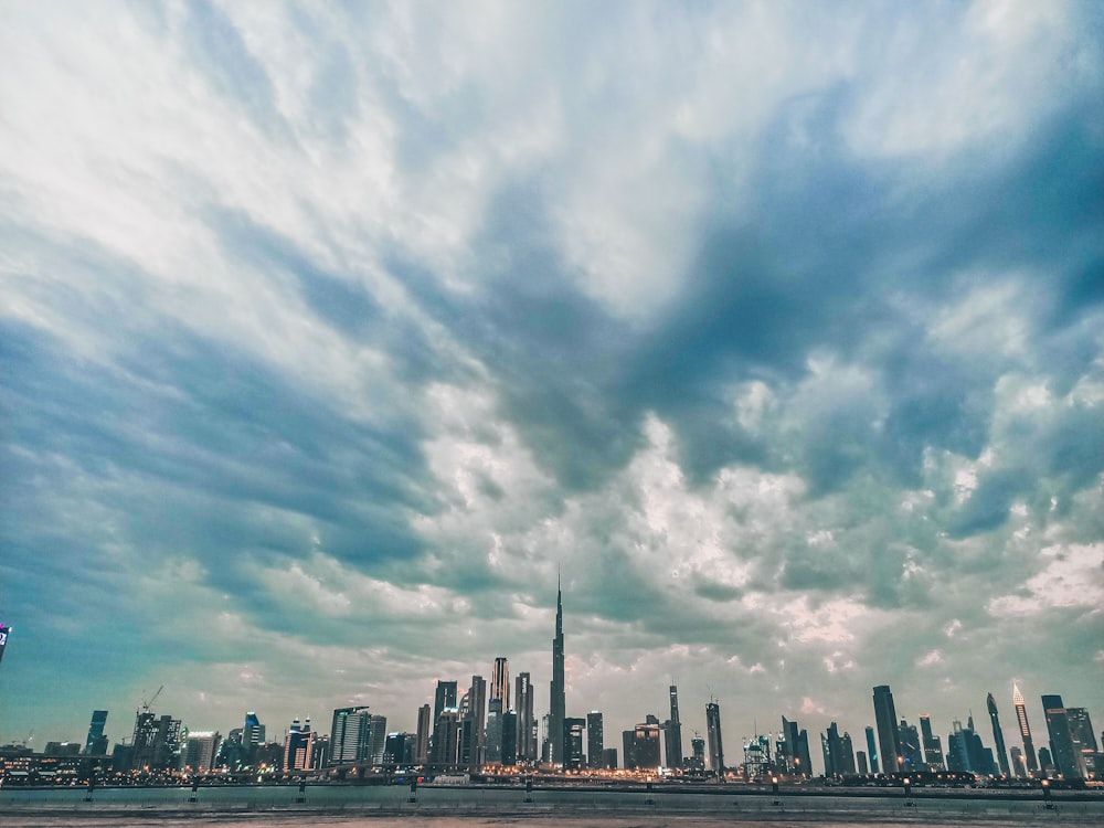 city buildings under white clouds and blue sky during daytime