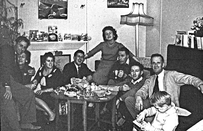 A diverse group of people watching TV together in a cozy living room.
