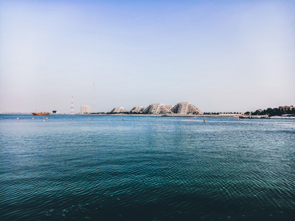 body of water near city buildings during daytime