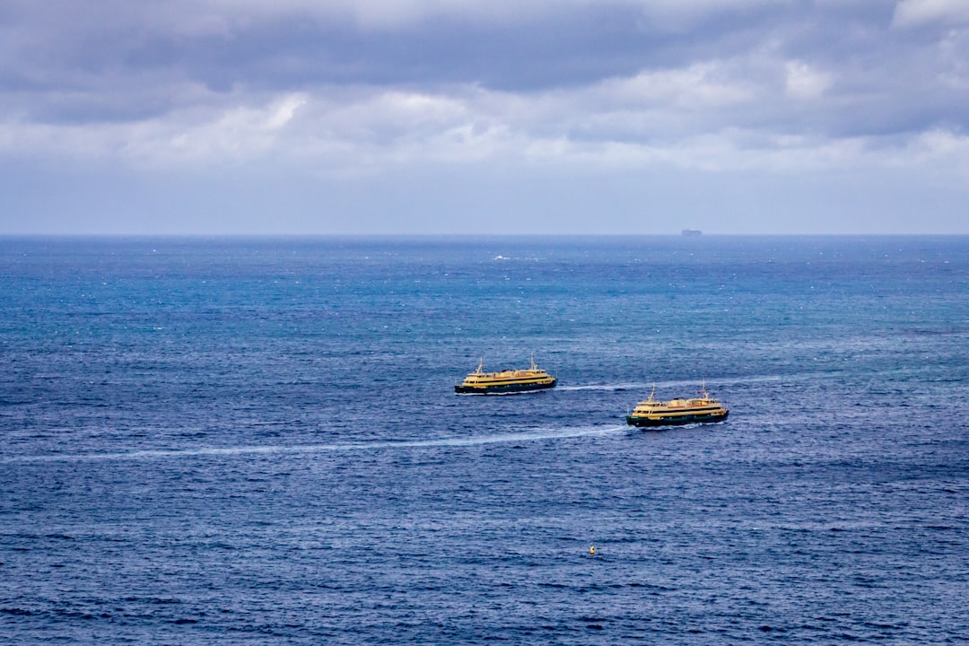 yellow and black boat on sea under white clouds during daytime