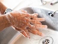person washing hands on sink