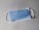 A disposable blue surgical mask with white ear loops lying flat on a neutral-colored surface.