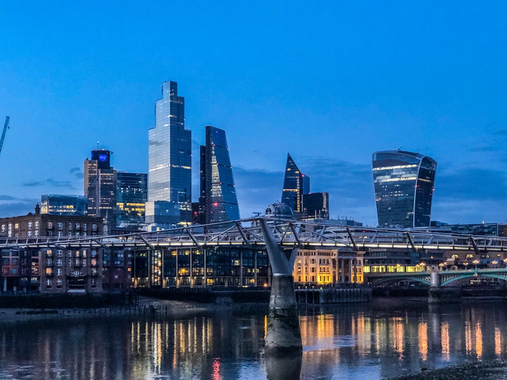 city buildings near body of water during night time