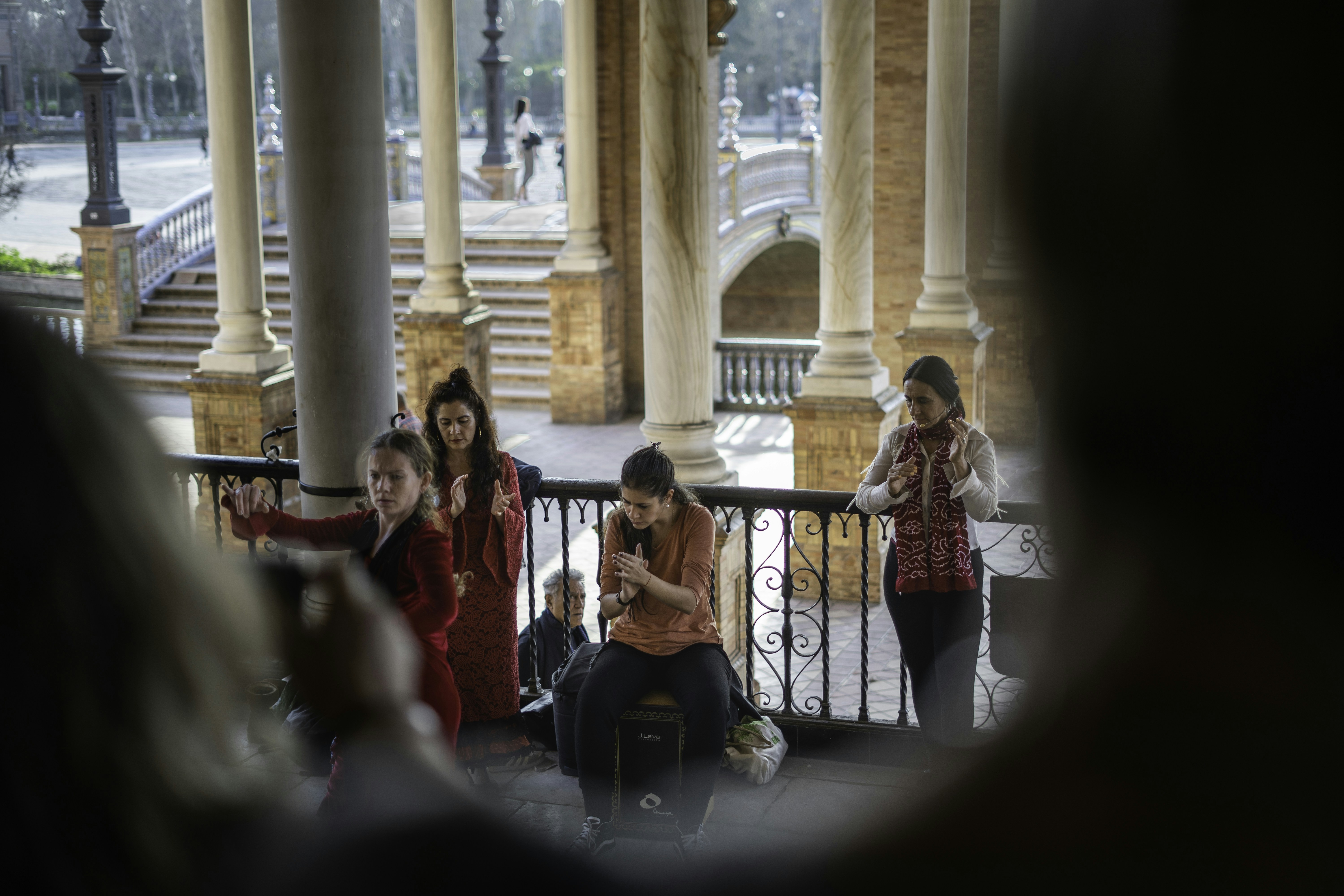 people sitting on chair near building during daytime, A Flamenco female dancer with other musicians in the famous square in Seville 🇪🇸