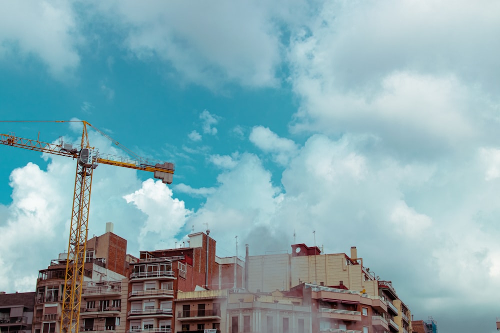 white and brown concrete buildings under white clouds and blue sky during daytime