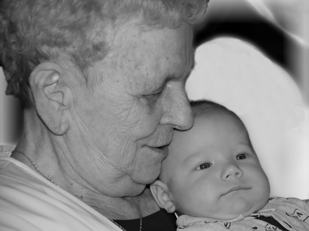 man in white shirt kissing baby in white shirt