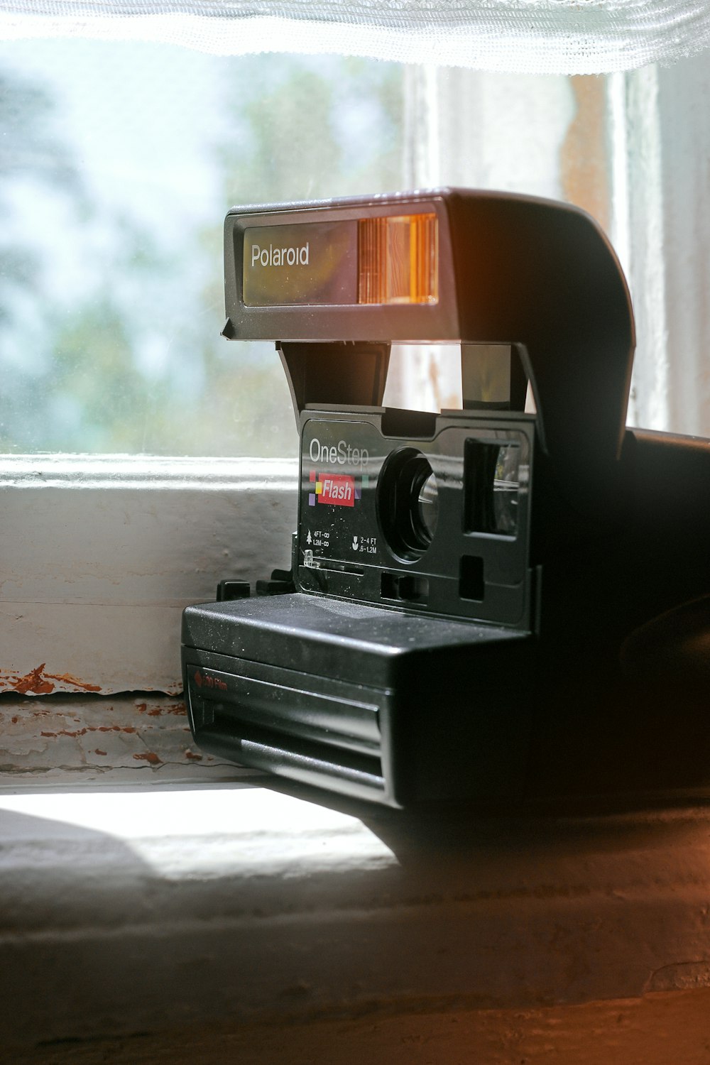 black and red polaroid camera on brown wooden table