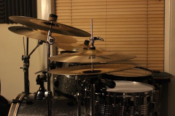 Close-up of hands playing percussion drums in a cozy, dimly lit studio.