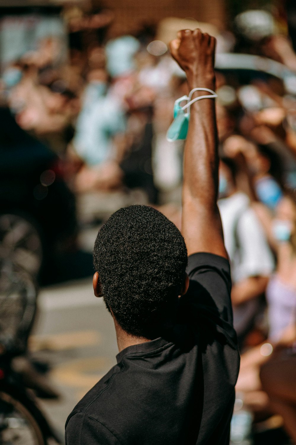 man in black t-shirt raising his right hand