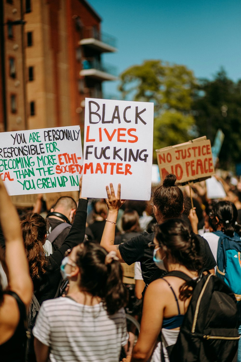 people holding white and blue signage during daytime