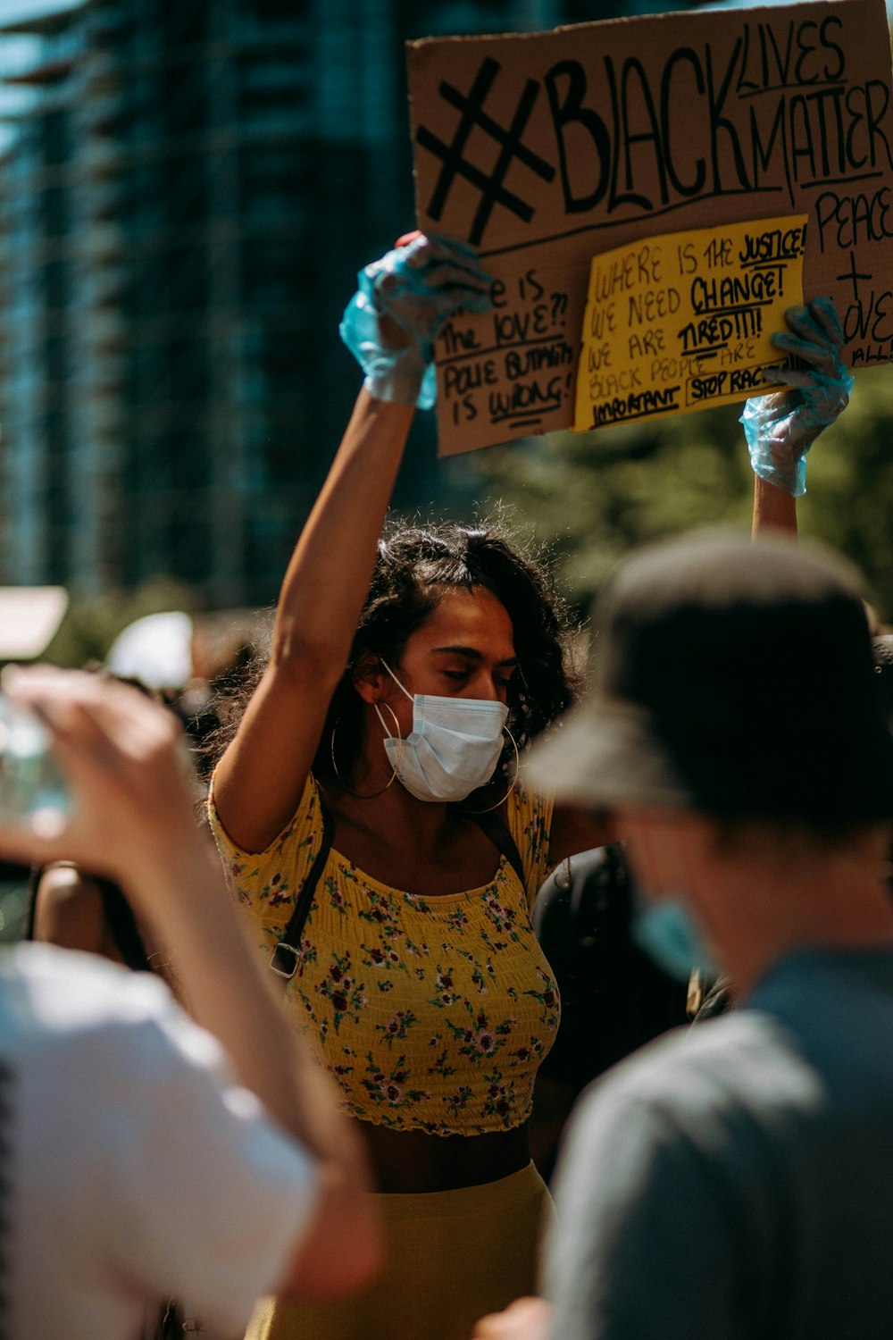 woman in yellow and black tank top wearing white face mask