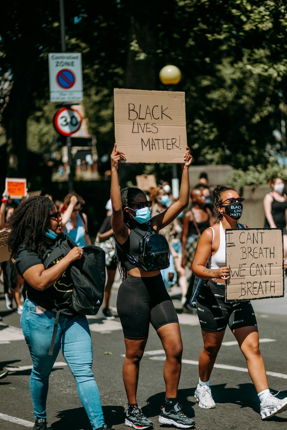 group of women in black and white tank top holding brown wooden board during daytime