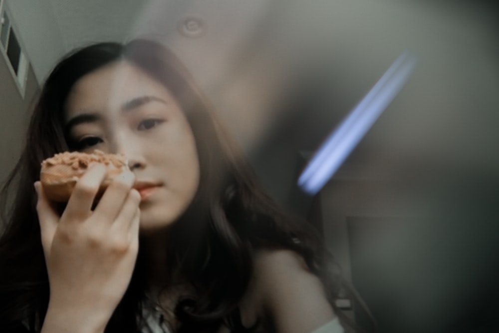 woman in black tank top holding brown and white food