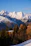 Golden sunrise lighting up the cozy alpine-shaped cottage with a backdrop of snow-capped peaks.
