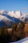 Golden sunrise lighting up the cozy alpine-shaped cottage with a backdrop of snow-capped peaks.