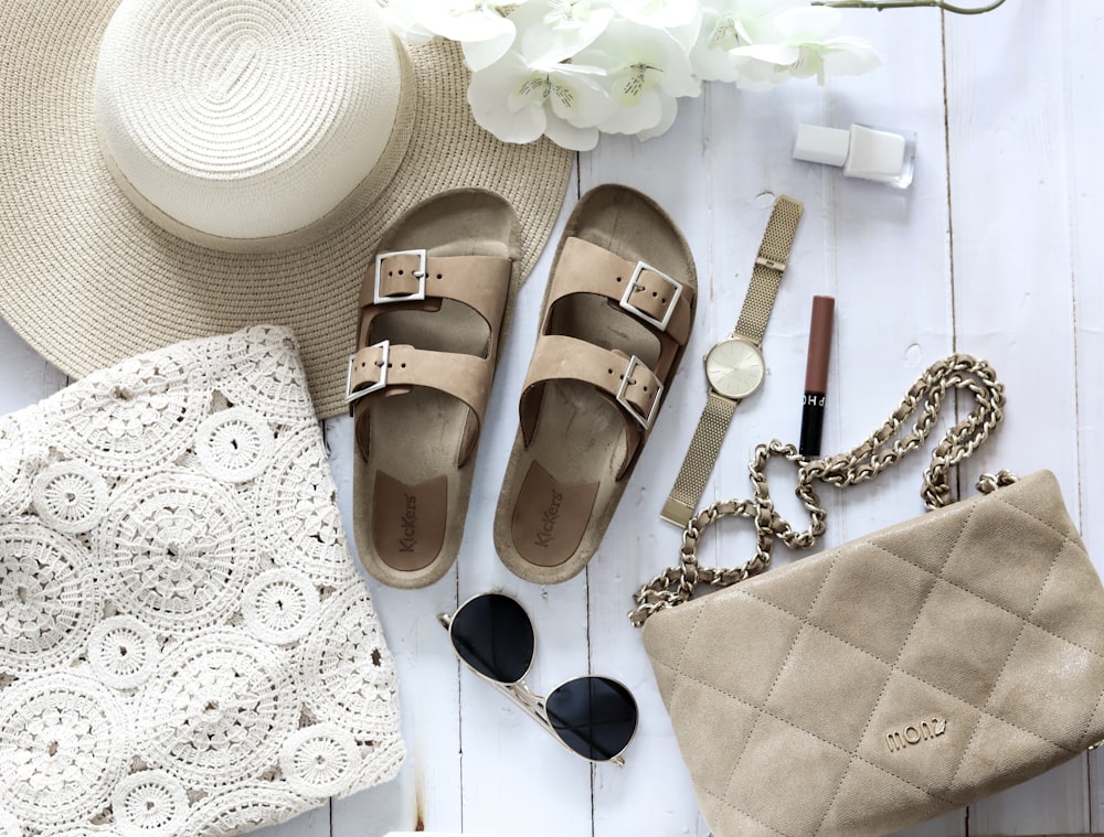 brown leather sandals beside black sunglasses