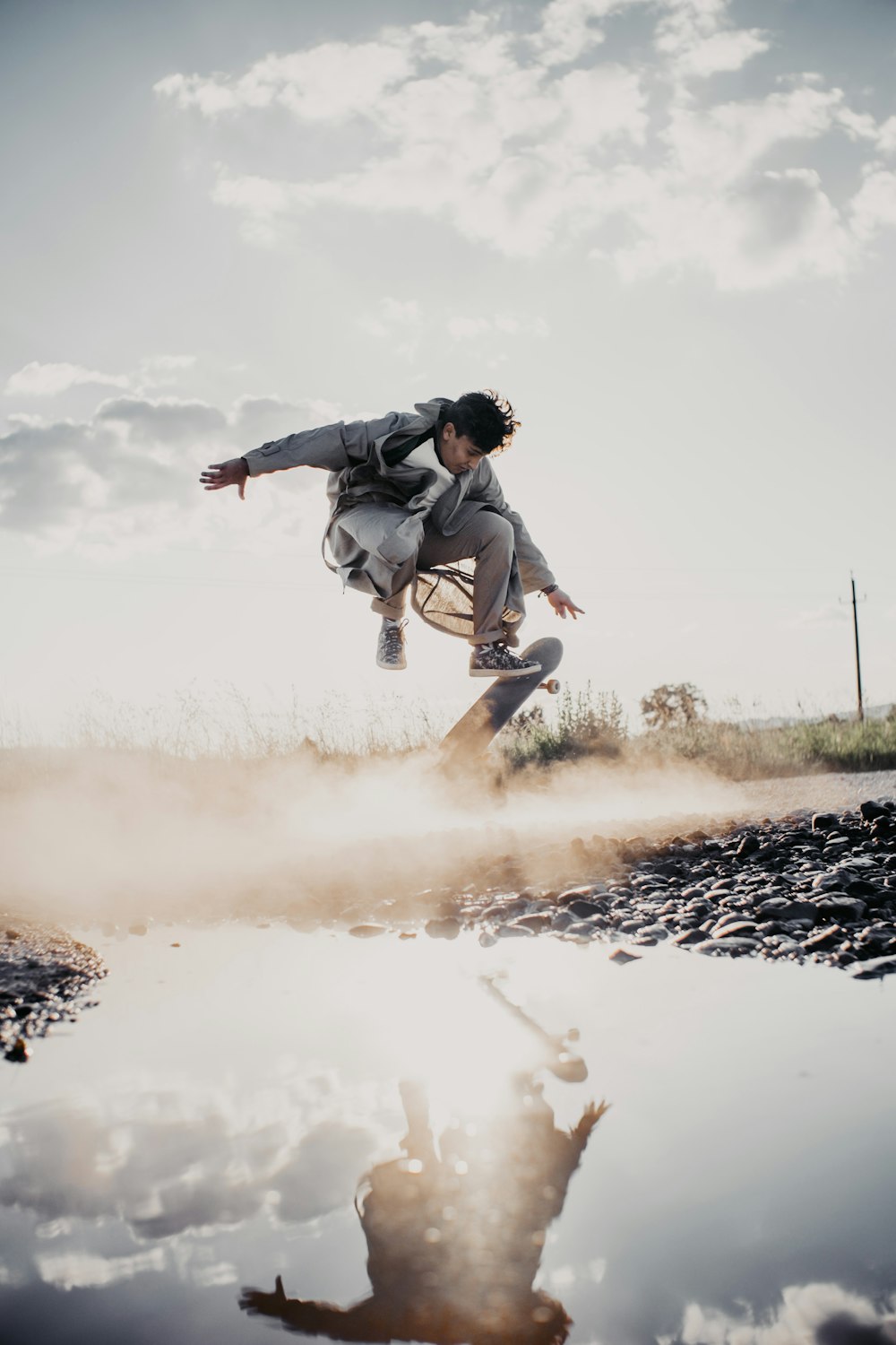 man in white shirt and black pants jumping on brown field during daytime