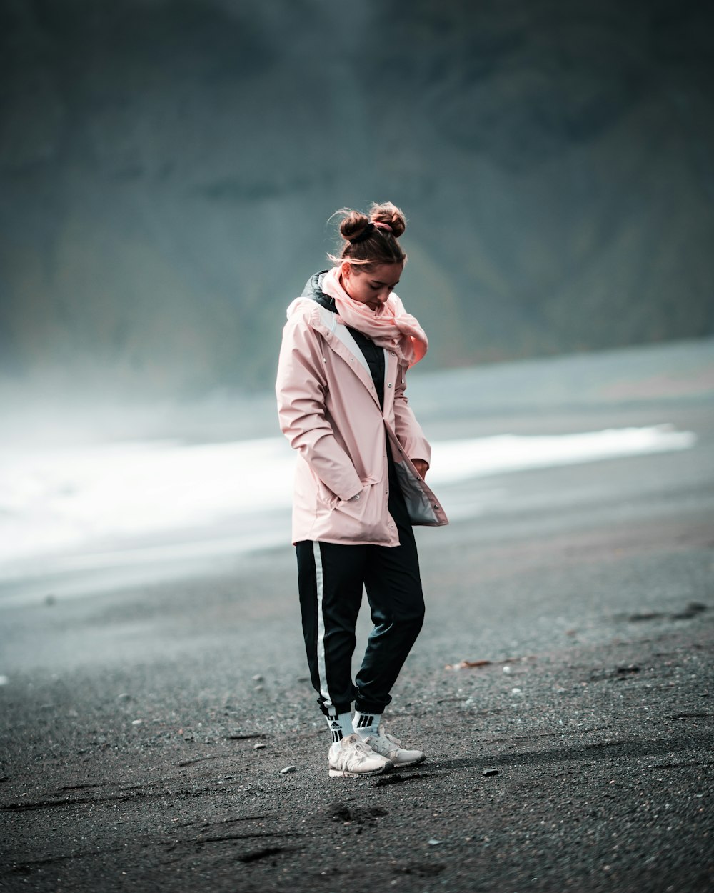 woman in pink coat standing on road during daytime