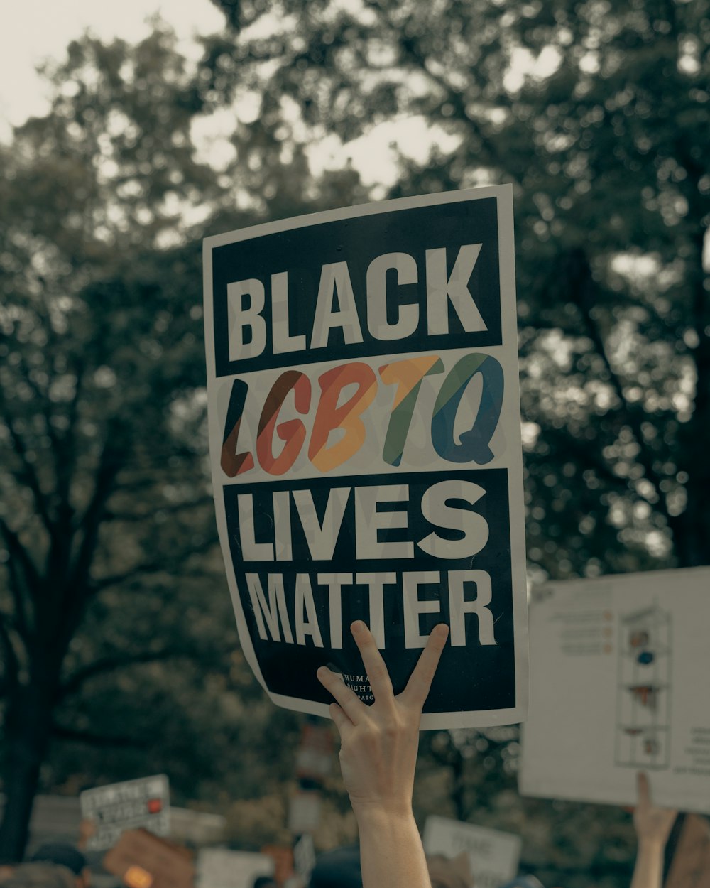 person holding white and black welcome to the beach signage