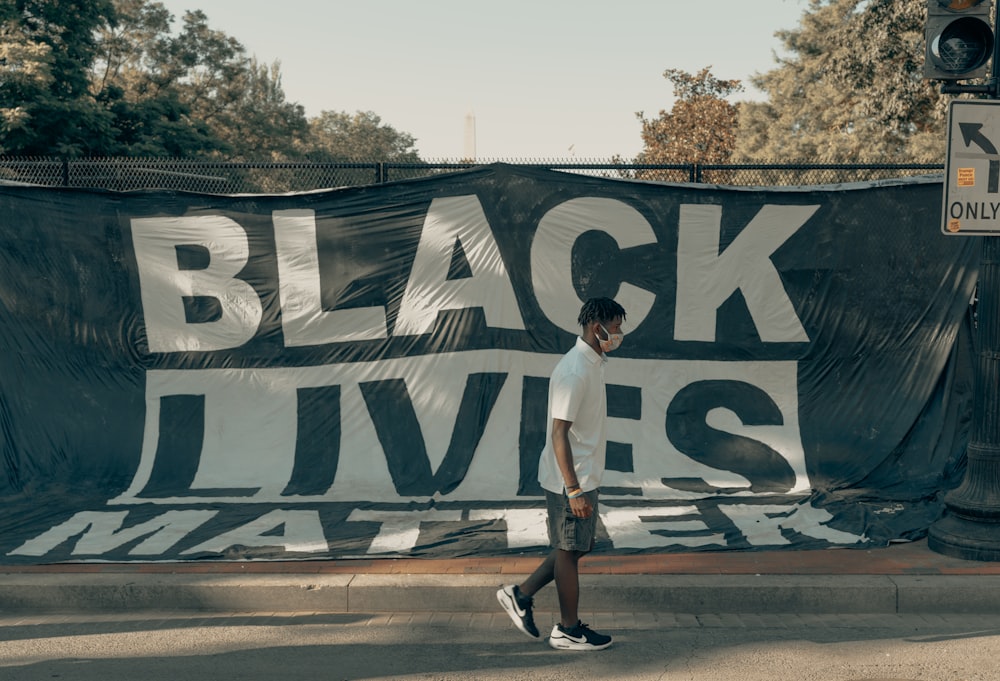 Black Lives Matter banner with Black man walking in front