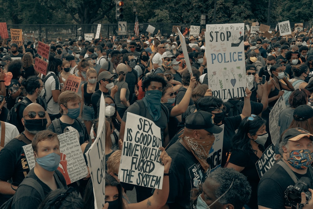 people holding white and black signage during daytime