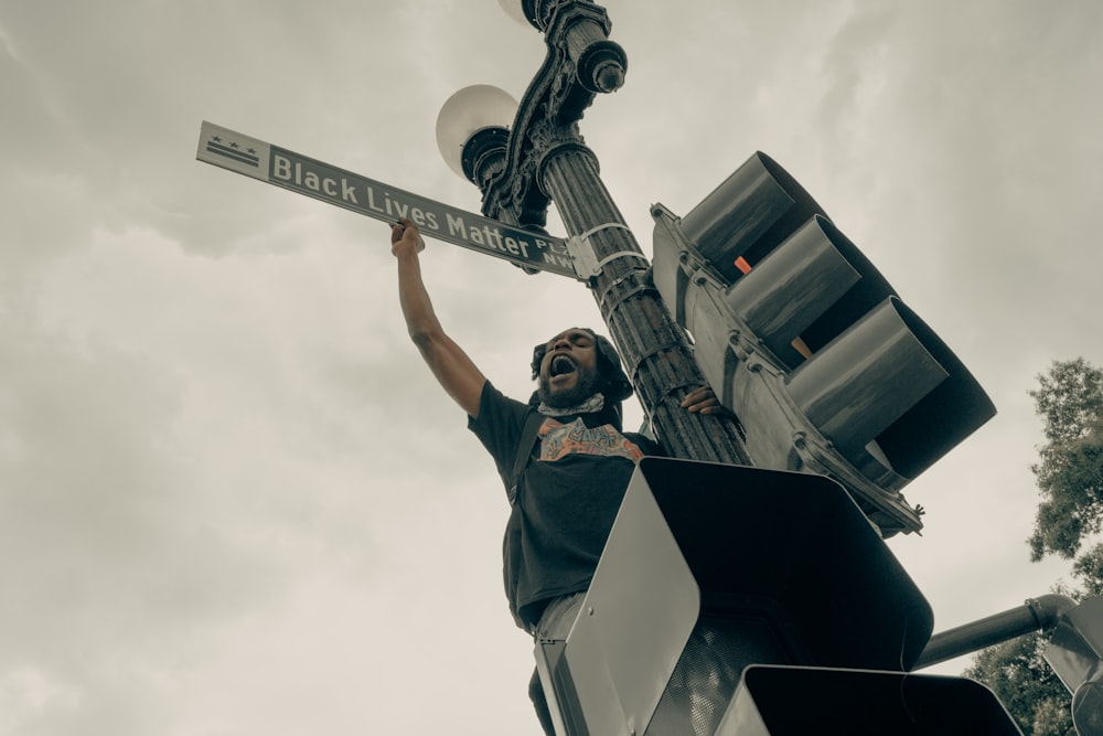 man in black jacket and pants standing on top of building statue