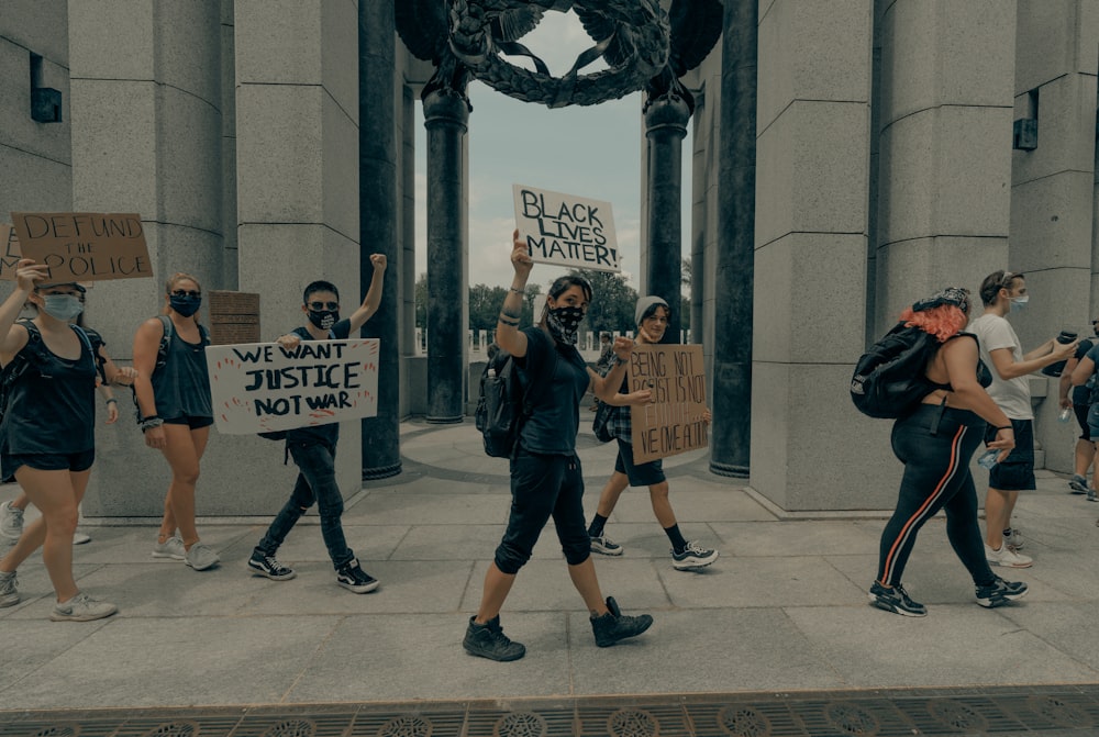 group of people holding white and orange signage