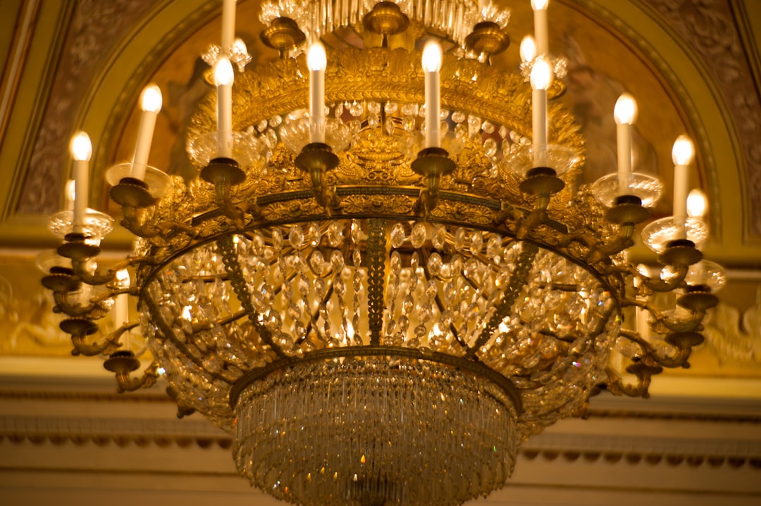 gold and white chandelier turned on in a building