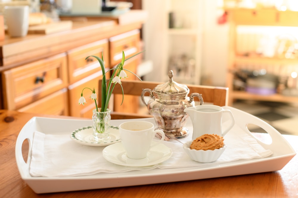 white ceramic teacup on white ceramic plate