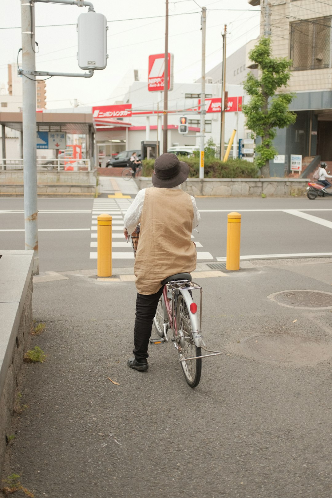 man in brown hoodie riding bicycle on road during daytime
