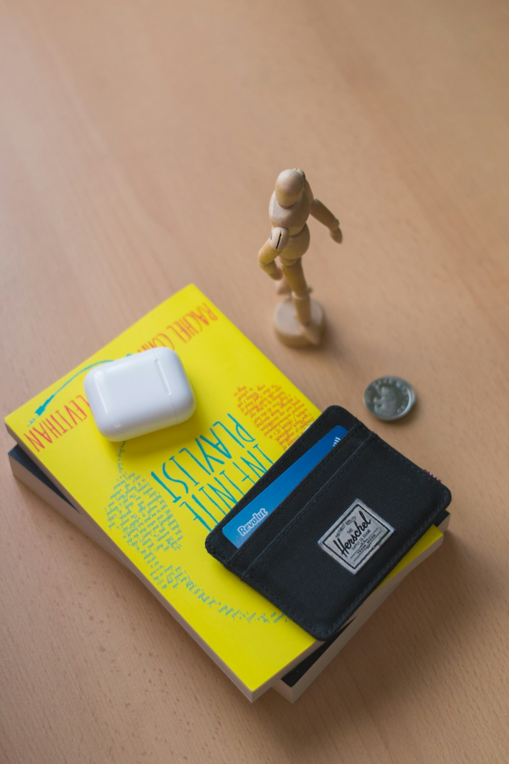 Chargeur Apple blanc à côté d’un portefeuille à deux volets en cuir noir