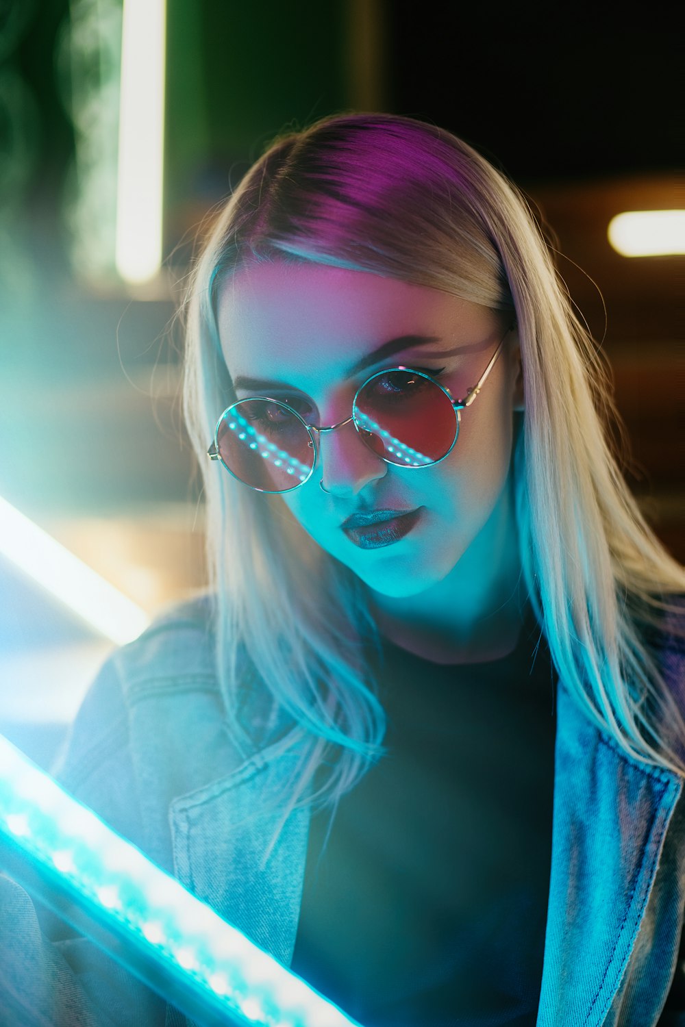 woman in blue denim jacket wearing black framed eyeglasses