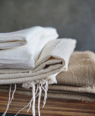 white textile on brown wooden table