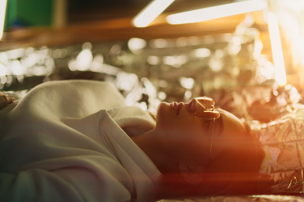 person in white long sleeve shirt lying on bed