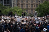 A crowd of protesters holding signs in a city square.