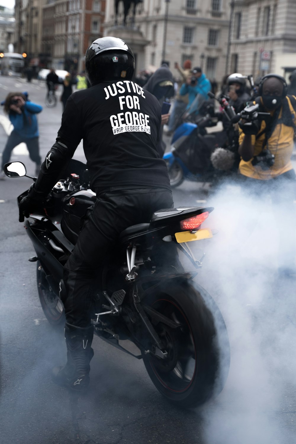Mann im schwarz-weißen Motorradanzug fährt schwarzes Sportrad