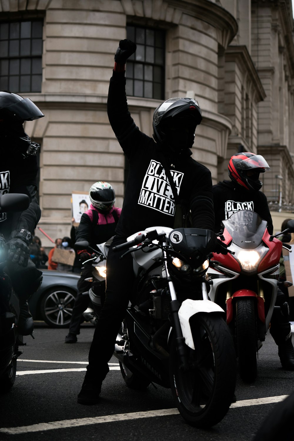 흑인과 백인 오토바이 헬멧을 쓴 남자 빨간색과 검은색 오토바이를 타고