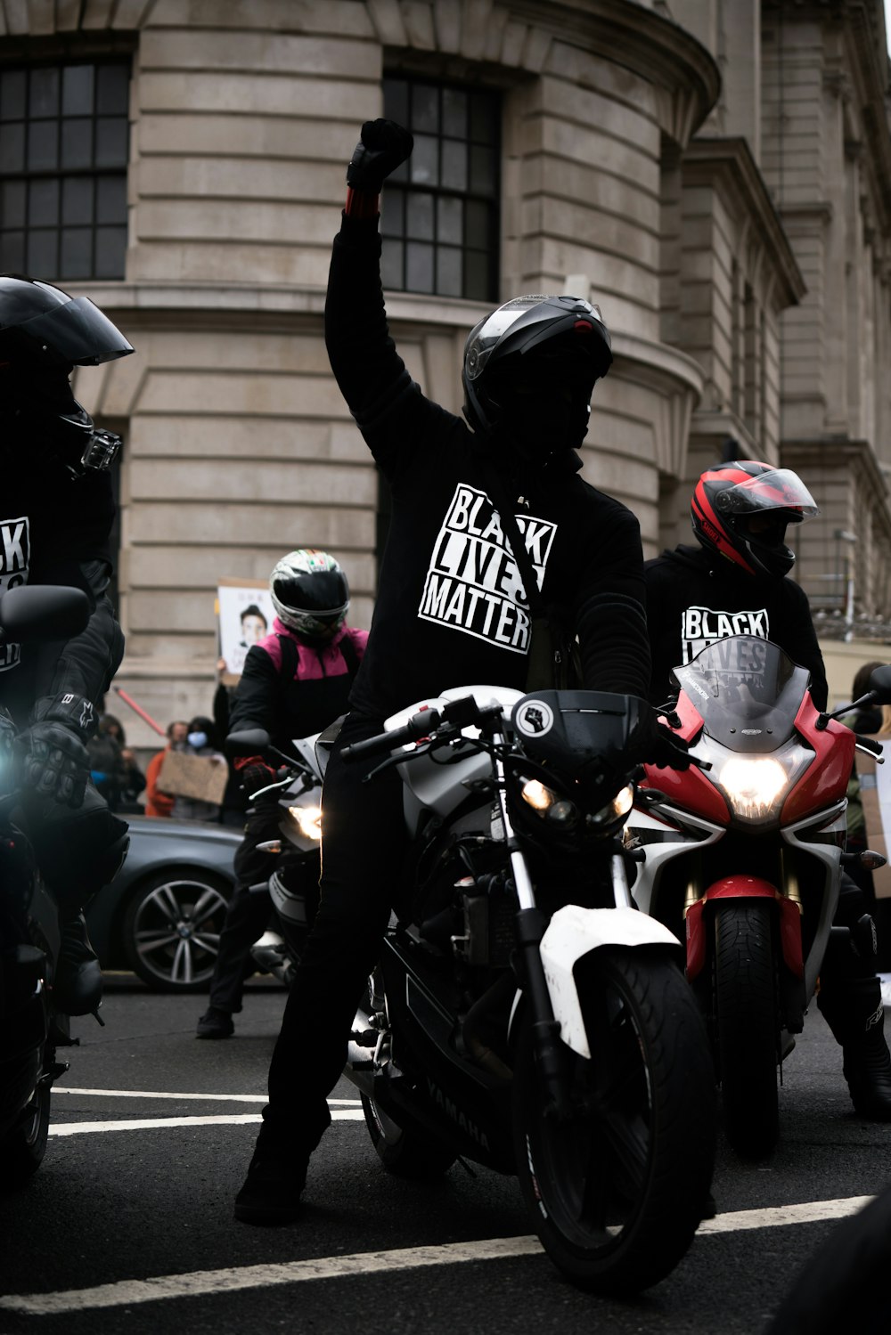 homme en noir et blanc casque de moto conduisant moto rouge et noire