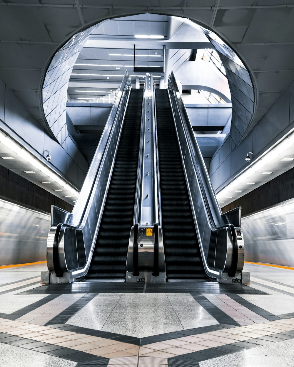 black escalator in a white tunnel