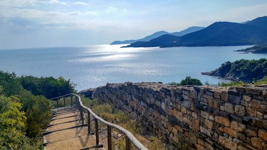 brown wooden fence on gray rocky shore during daytime in Stagira (ancient city) Greece