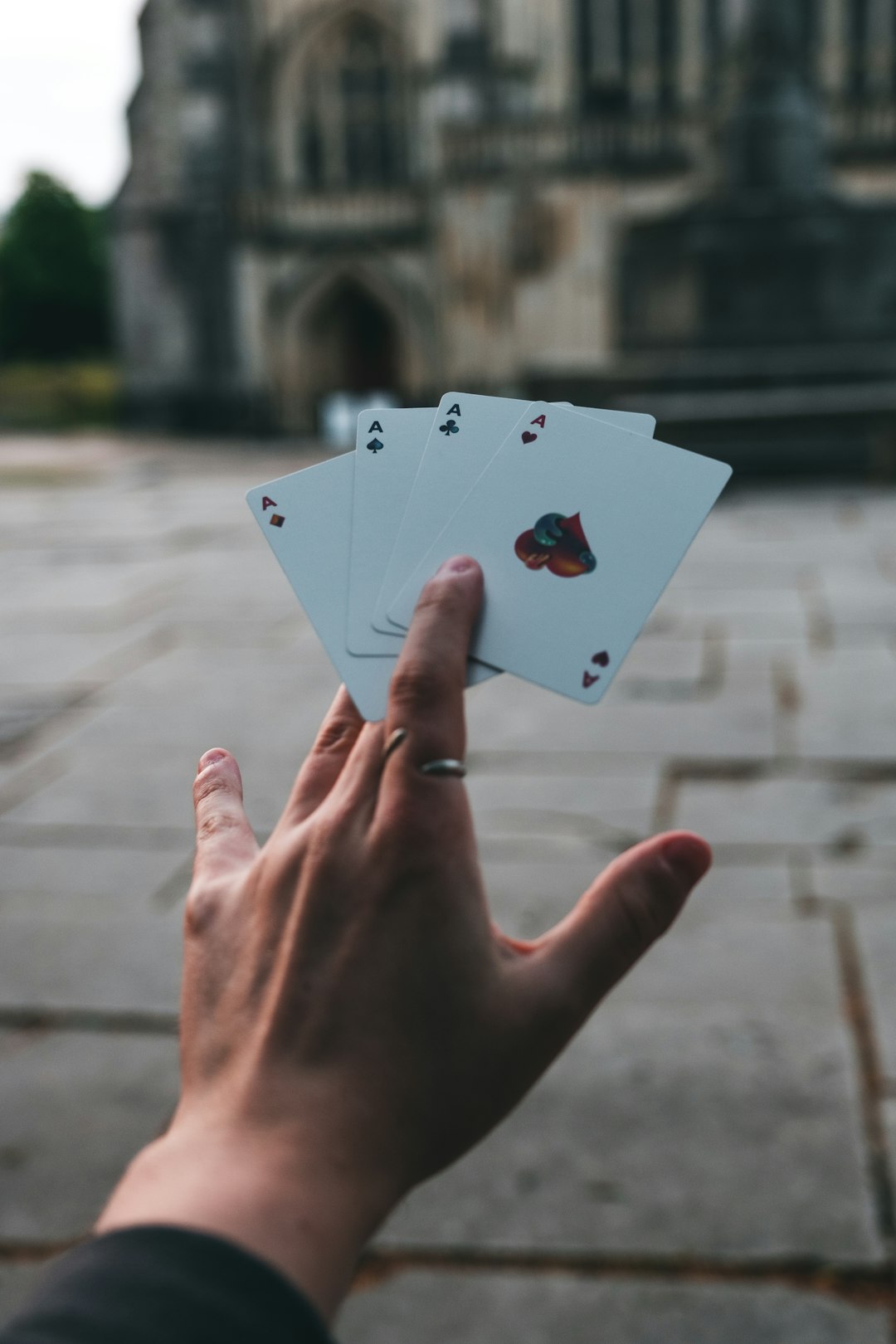 person holding 2 of hearts playing card